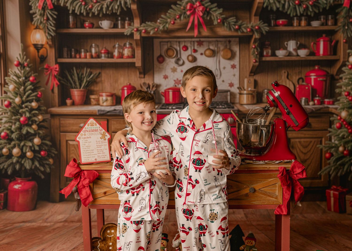 A festive Christmas photo session featuring matching holiday pajamas in a cozy room with decorated trees and decor.