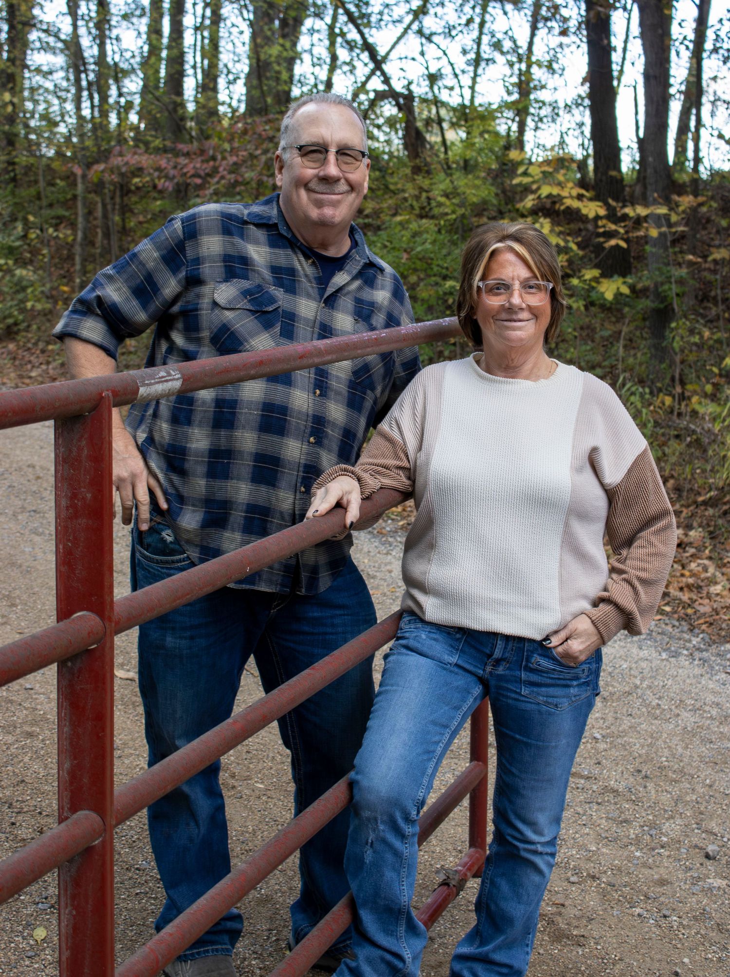 Group posing casually against rustic wooden railing on nature trail.
