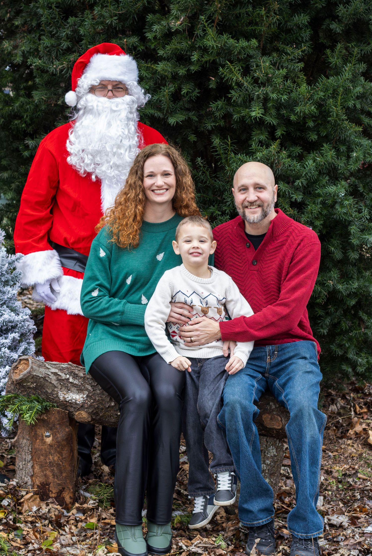 A holiday photo session outdoors with Santa Claus on a rustic wooden bench.