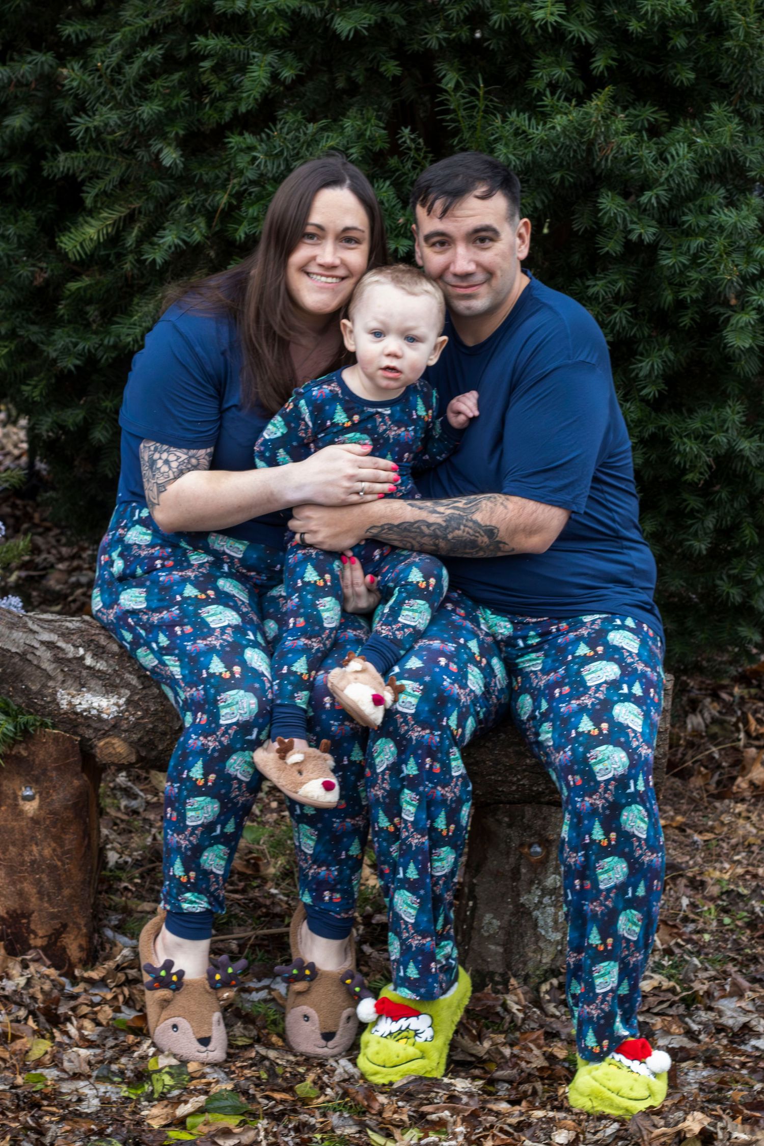 A family wearing matching blue pajamas poses for casual photos outdoors.
