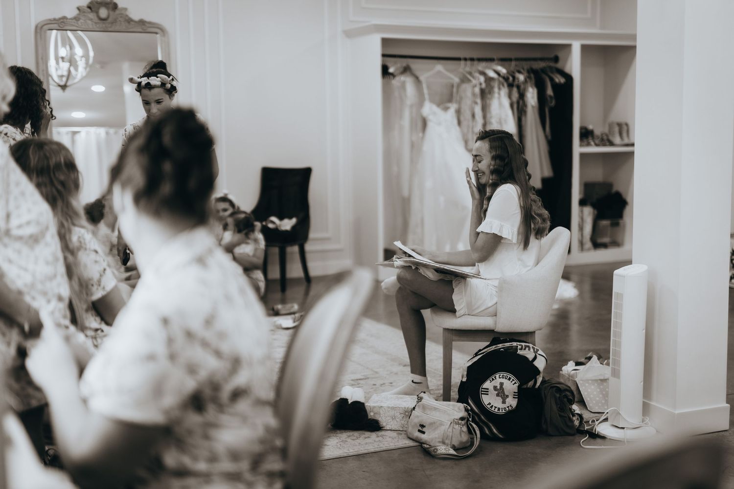 Bridesmaids gather in a dressing room as bride prepares for her wedding day in elegant bridal suite.