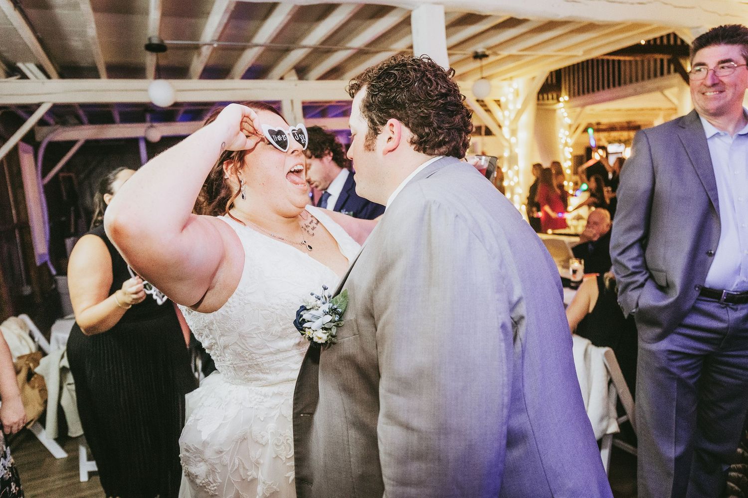 Wedding celebration in a rustic venue with wooden beams and ambient lighting.