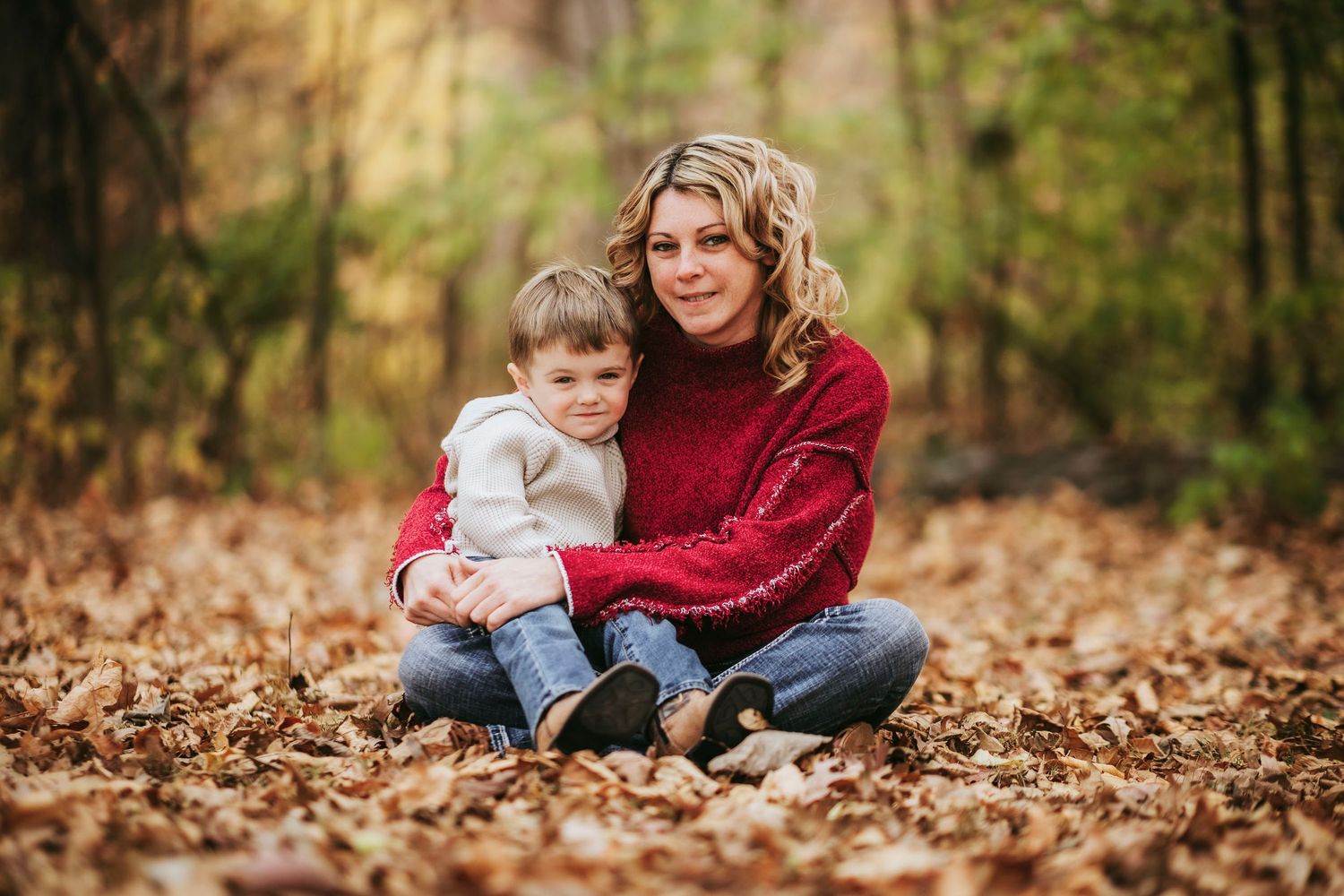 Family enjoying a playful autumn day together in fallen leaves at the park.