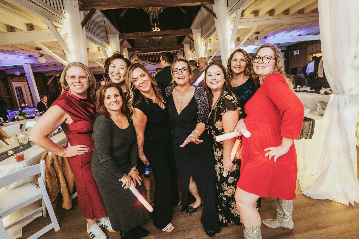 Group of wedding guests celebrating and dancing at an indoor reception venue.