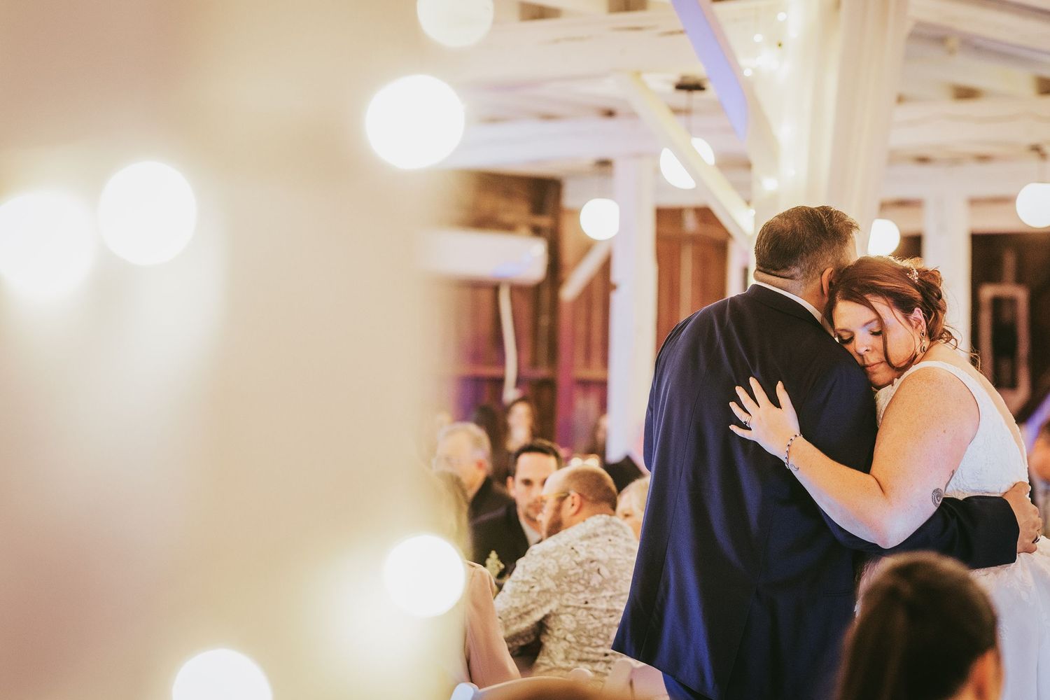 Wedding guests dancing and celebrating during an indoor reception.