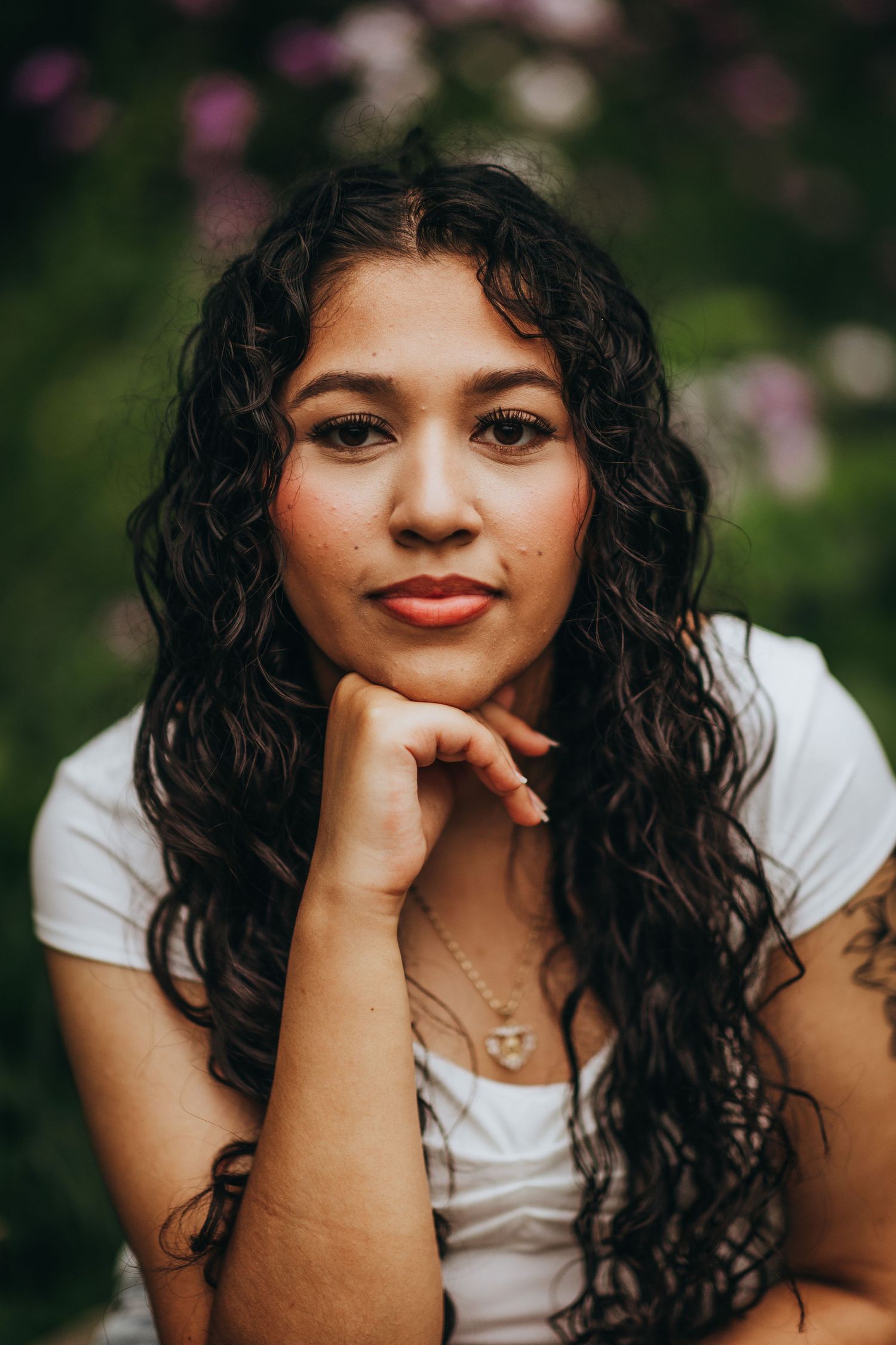A series of outdoor portrait photos showing curly dark hair and a white top against a soft natural background.