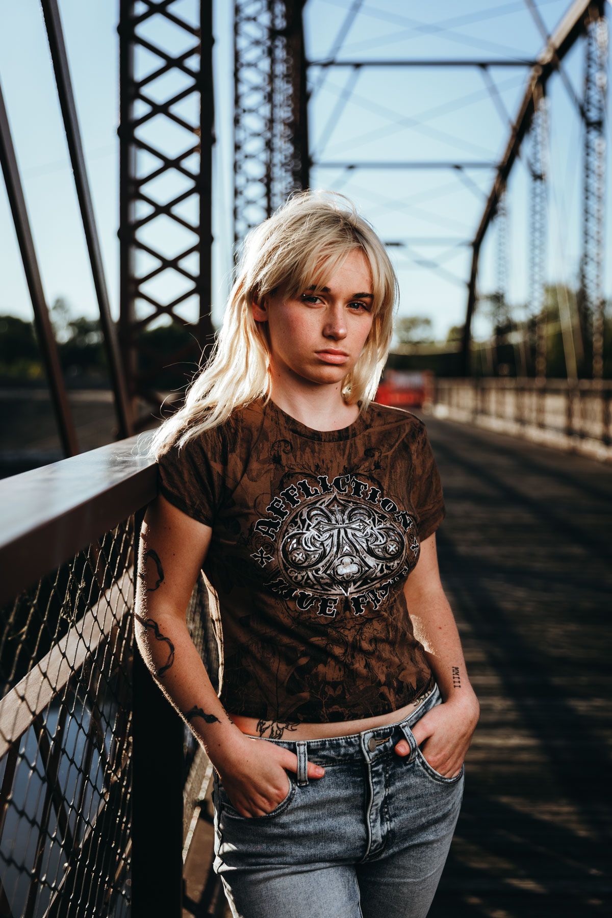 Fashion photo series on rustic metal bridge featuring vintage t-shirt and denim jeans styling.