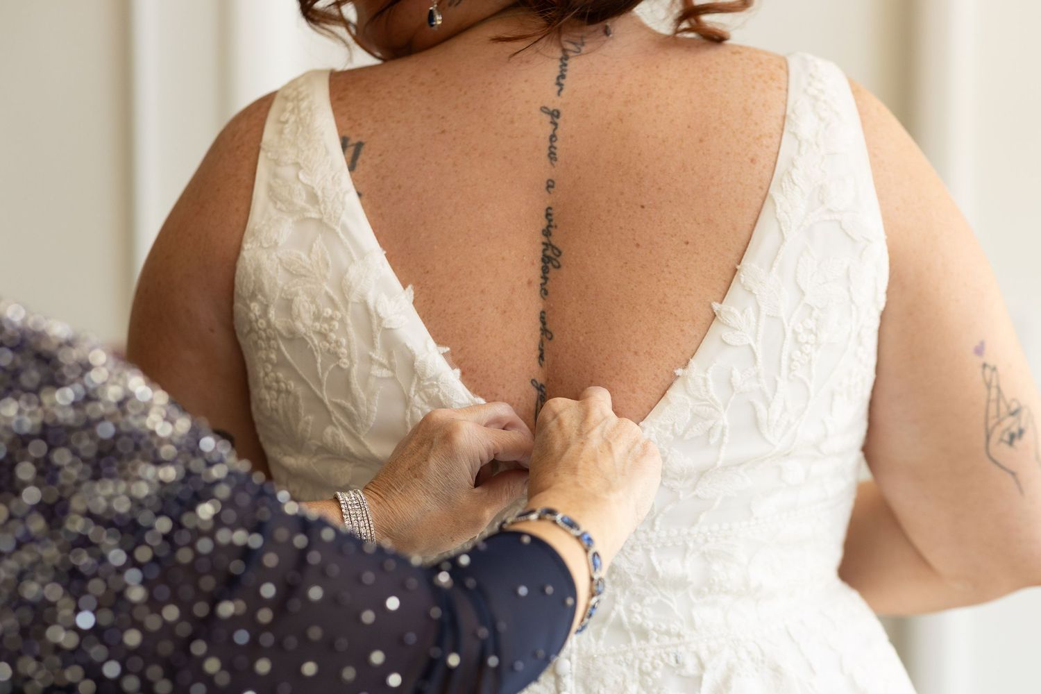 Close-up detail of white lace wedding dress bodice with delicate beading.