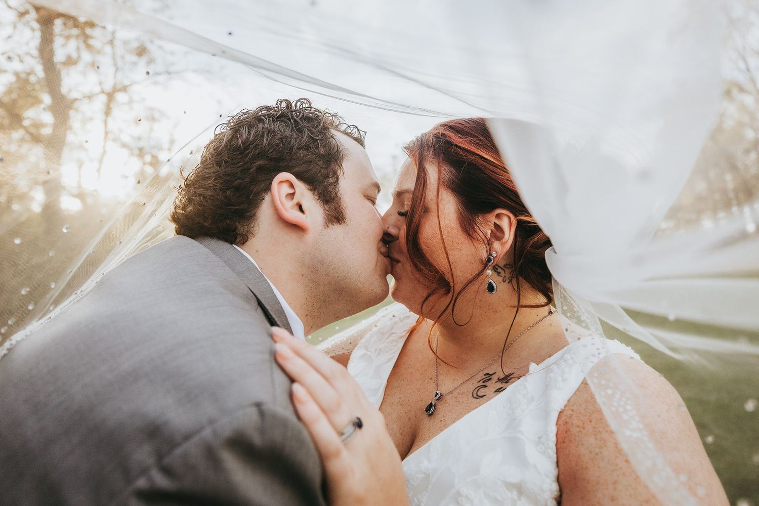 Romantic outdoor wedding portrait showing tender embrace between newlyweds.
