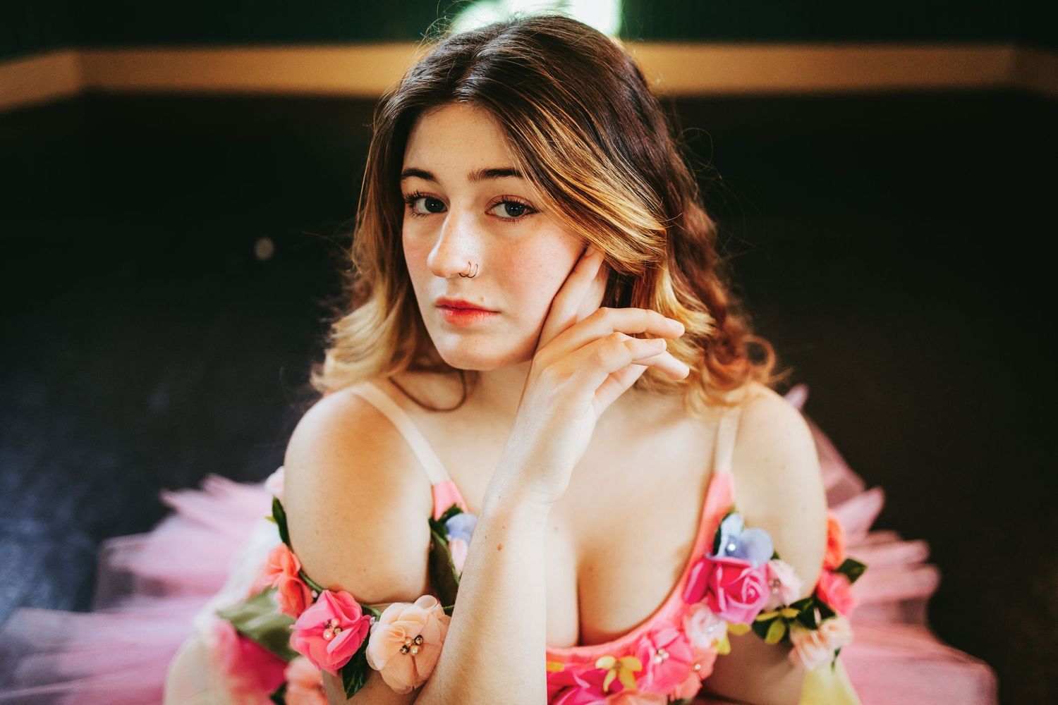 Woman in pink floral dress poses in multiple artistic portraits with soft lighting and romantic styling.