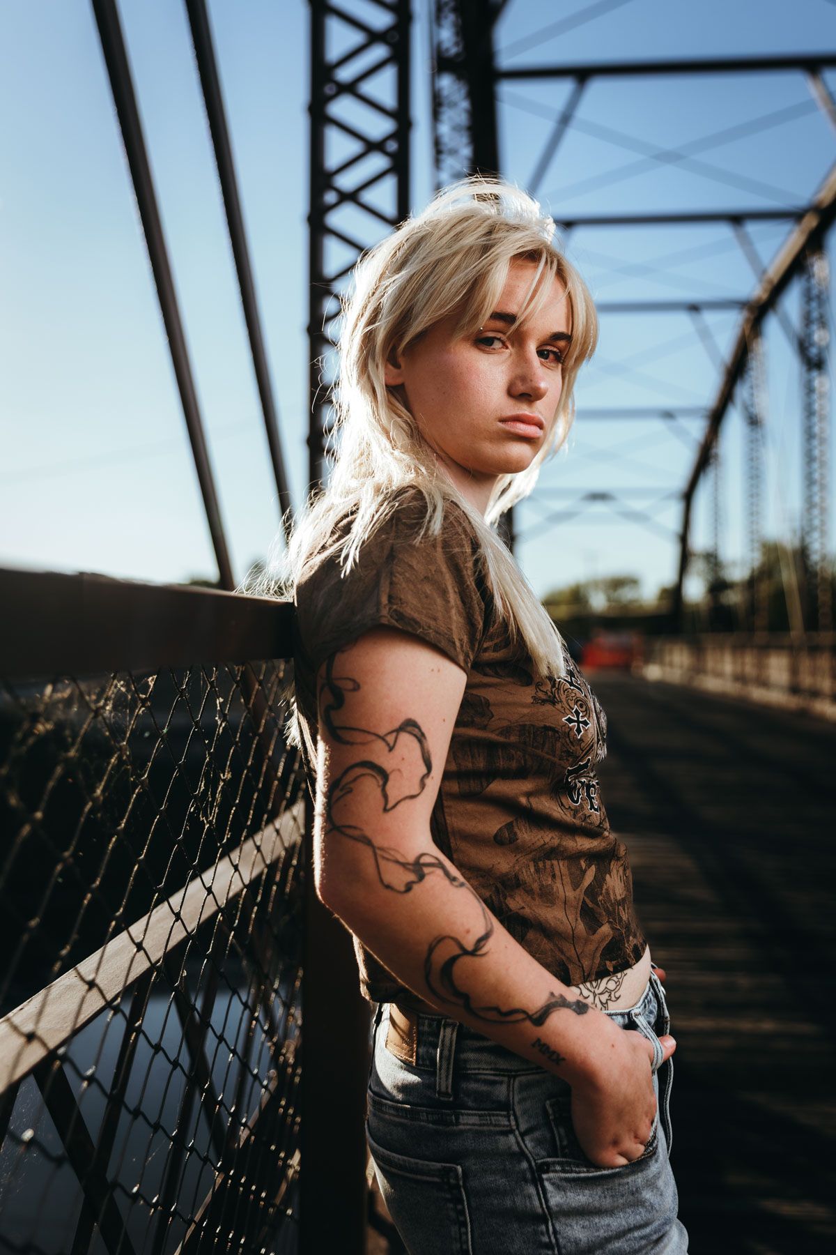 A series of photos showing someone with blonde hair posing near industrial metal structures at sunset.