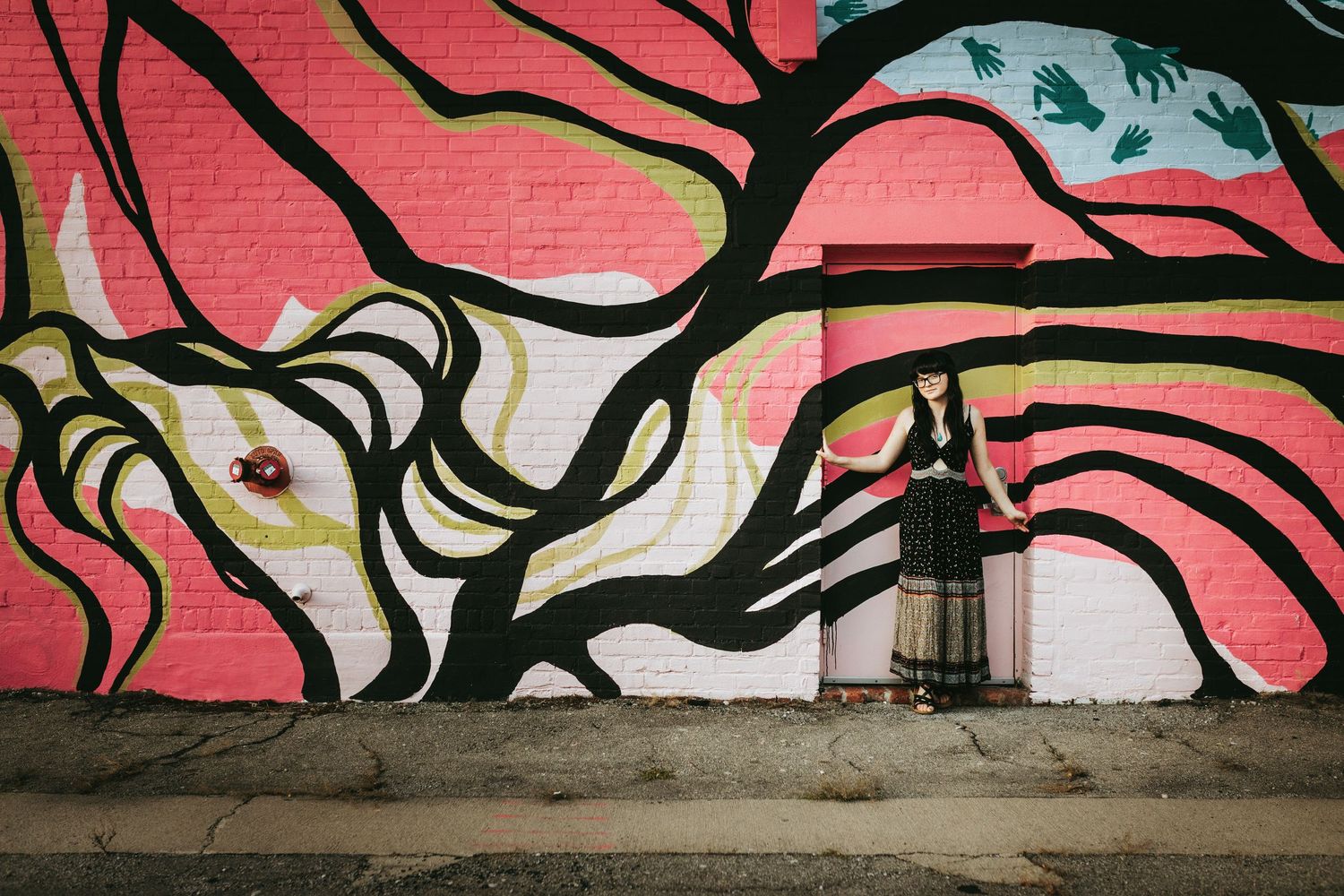 A long abstract graffiti mural featuring black and white swirling patterns against a vibrant pink wall.