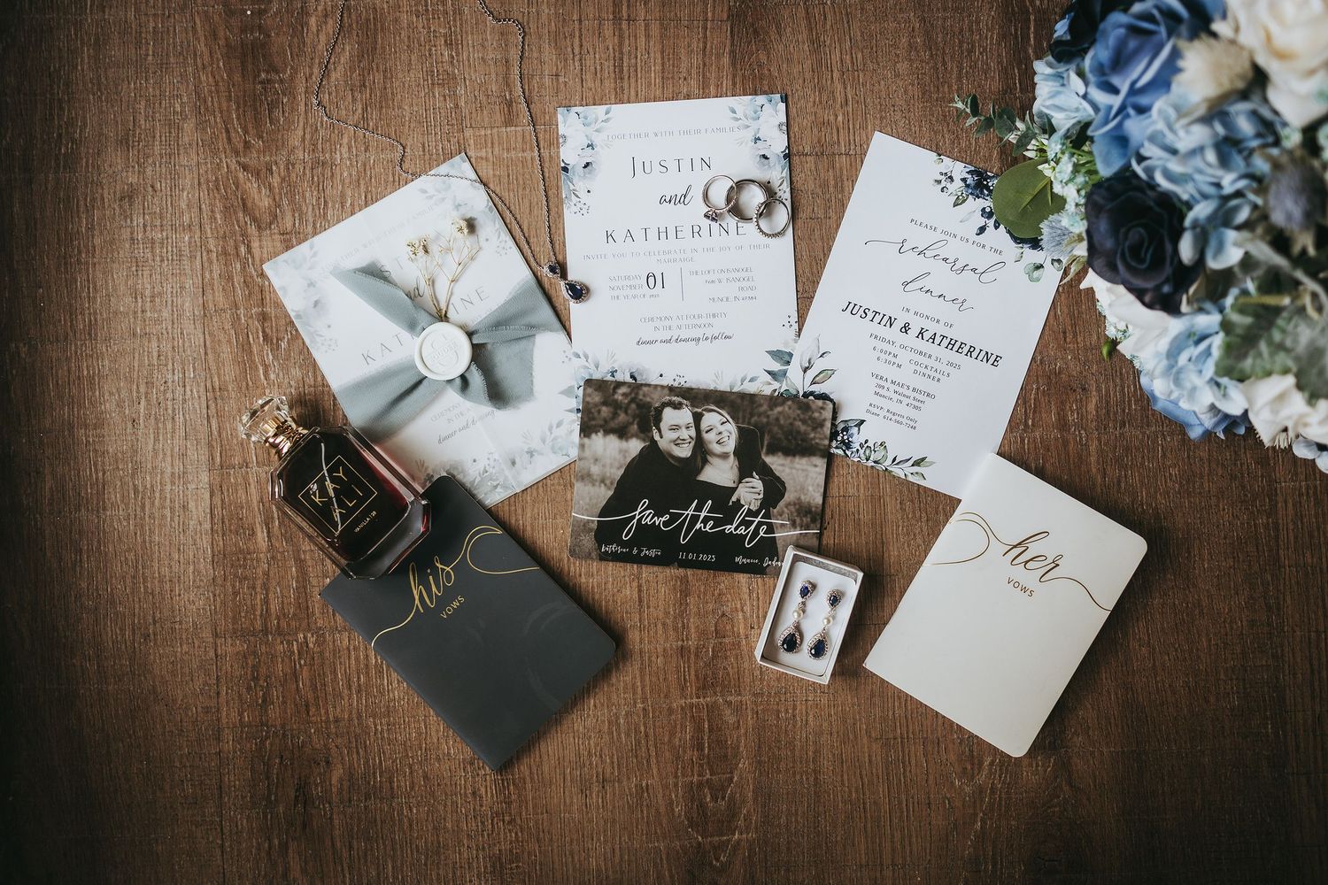 Wedding stationery and blue floral details arranged on wooden surface.
