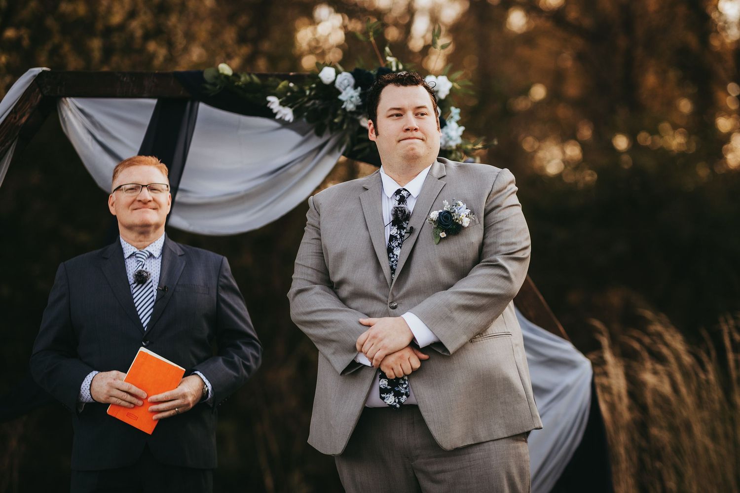 Wedding ceremony participants standing together outdoors during golden hour.