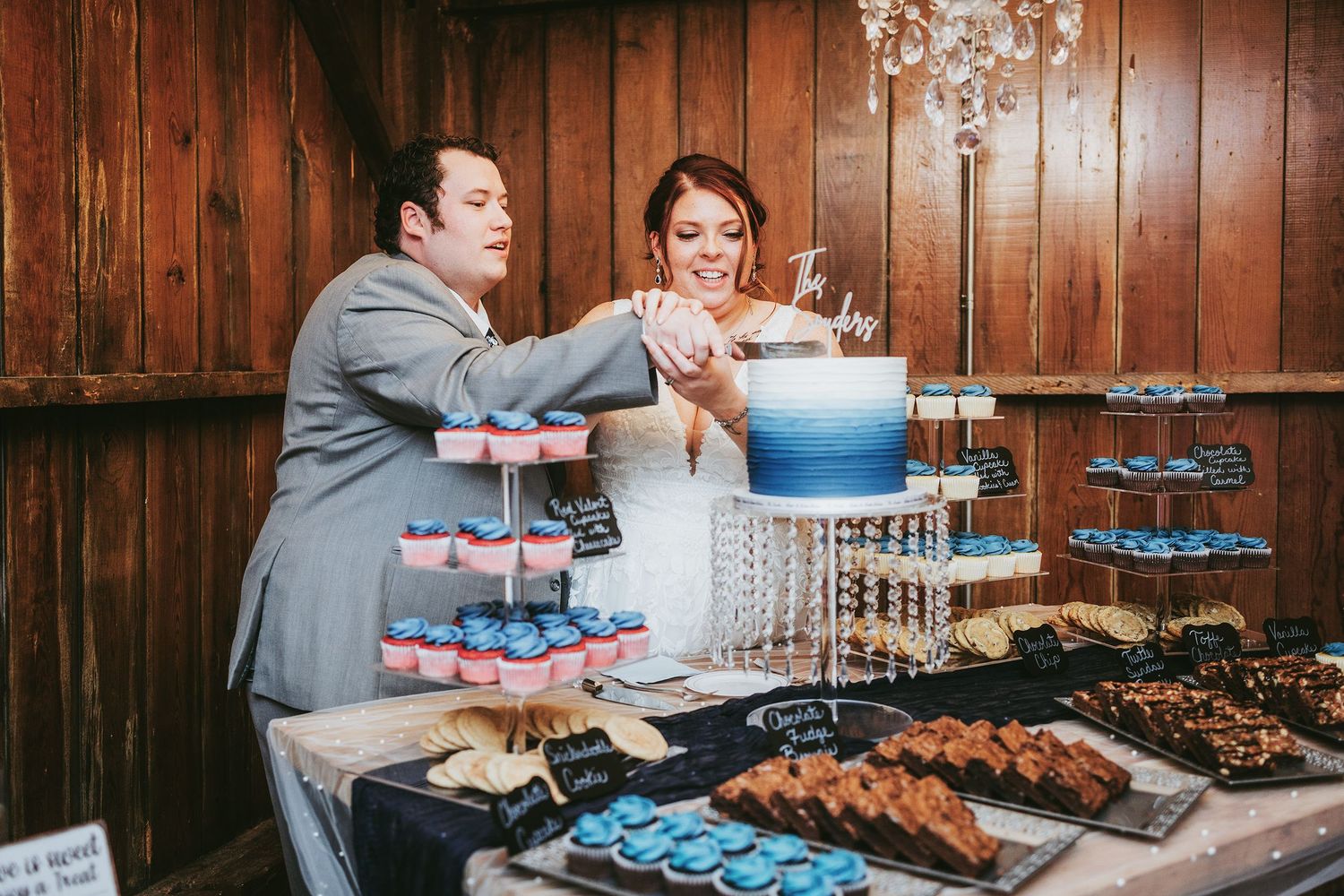 Wedding dessert table with blue and white cupcakes displayed on tiered stands.