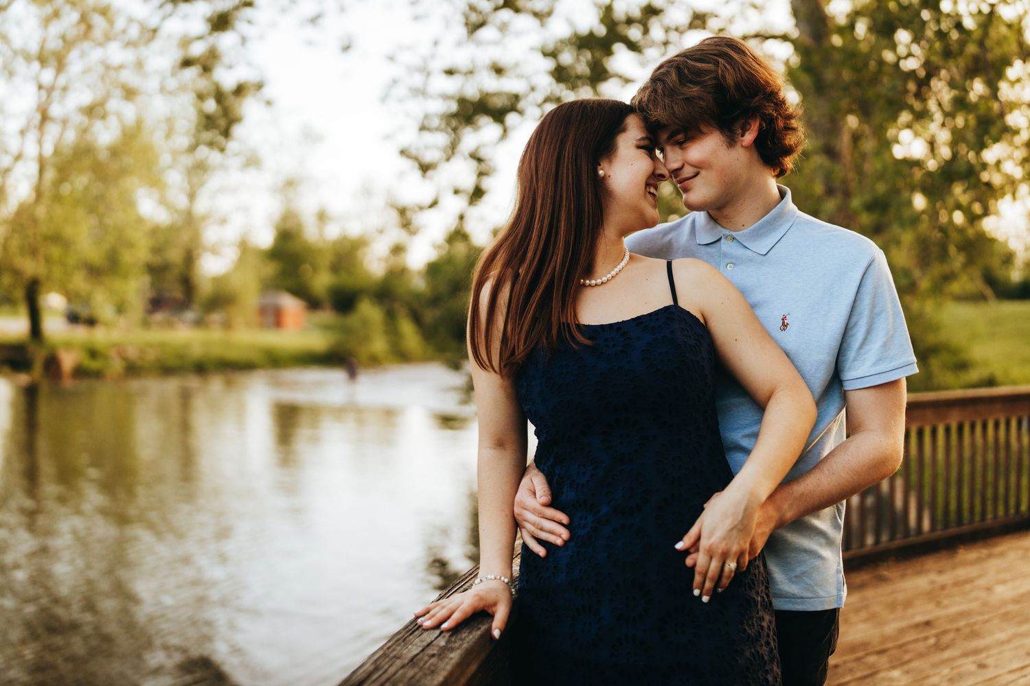 Romantic couple shares tender moments in golden sunlit park setting during autumn photoshoot.