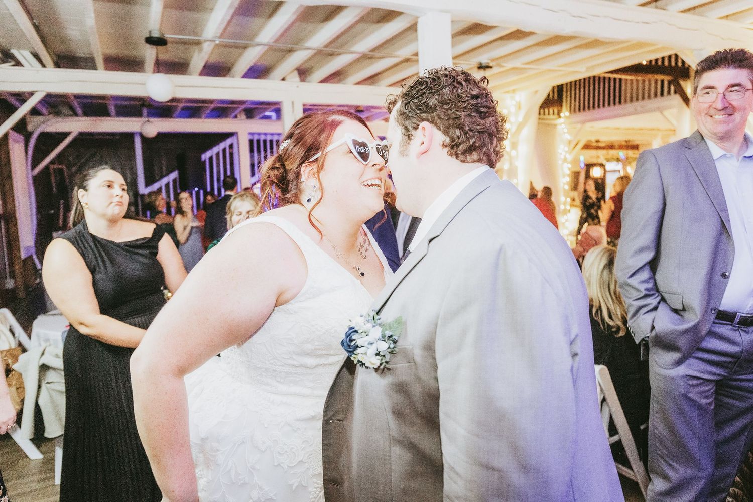 Wedding reception venue with exposed wooden beams and elegant lighting.