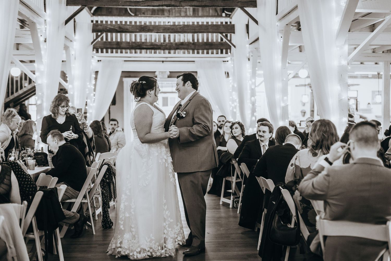 Wedding reception in an elegant white-pillared venue with guests seated at tables.
