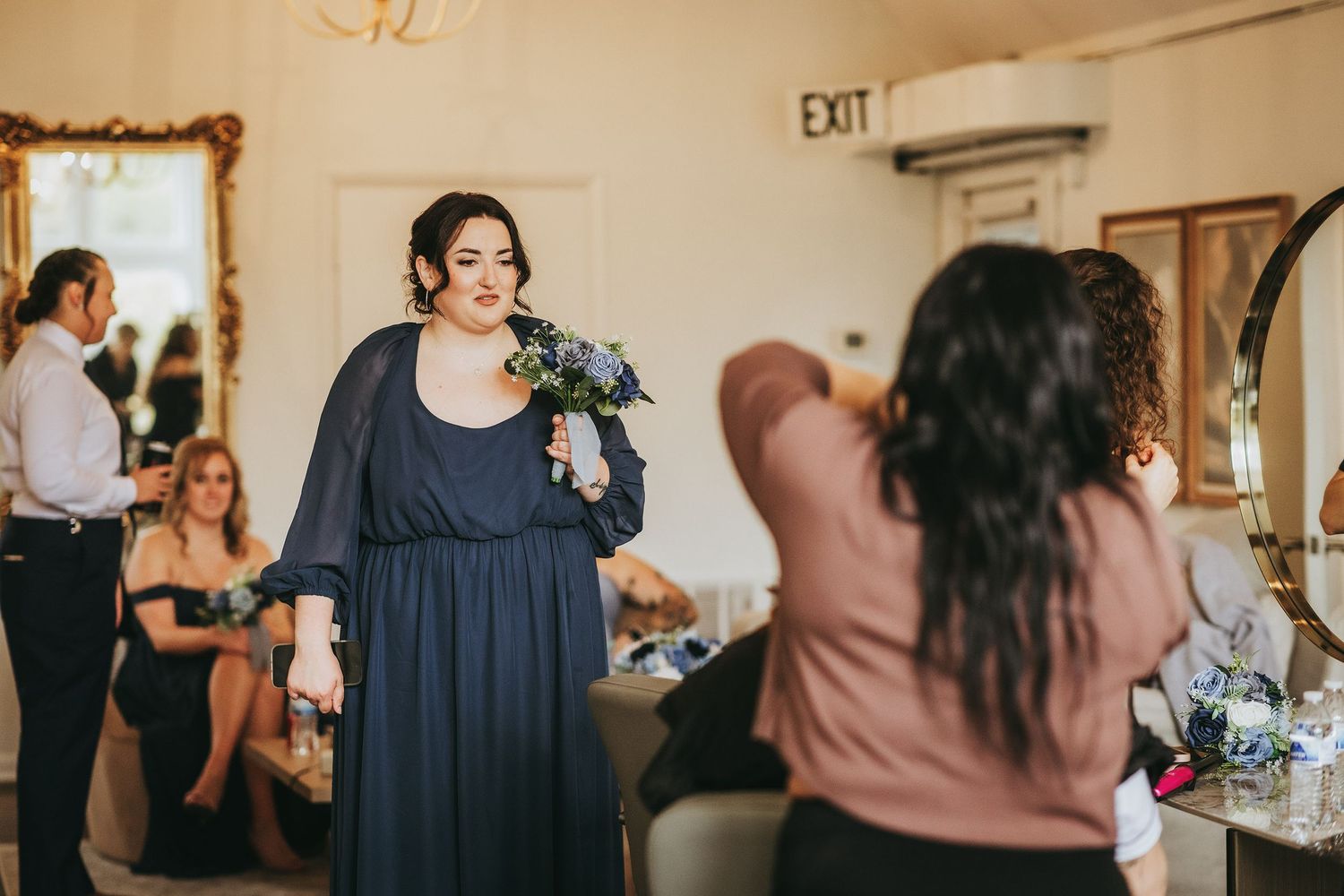 Wedding preparation scene in a light-filled room with vintage mirror.
