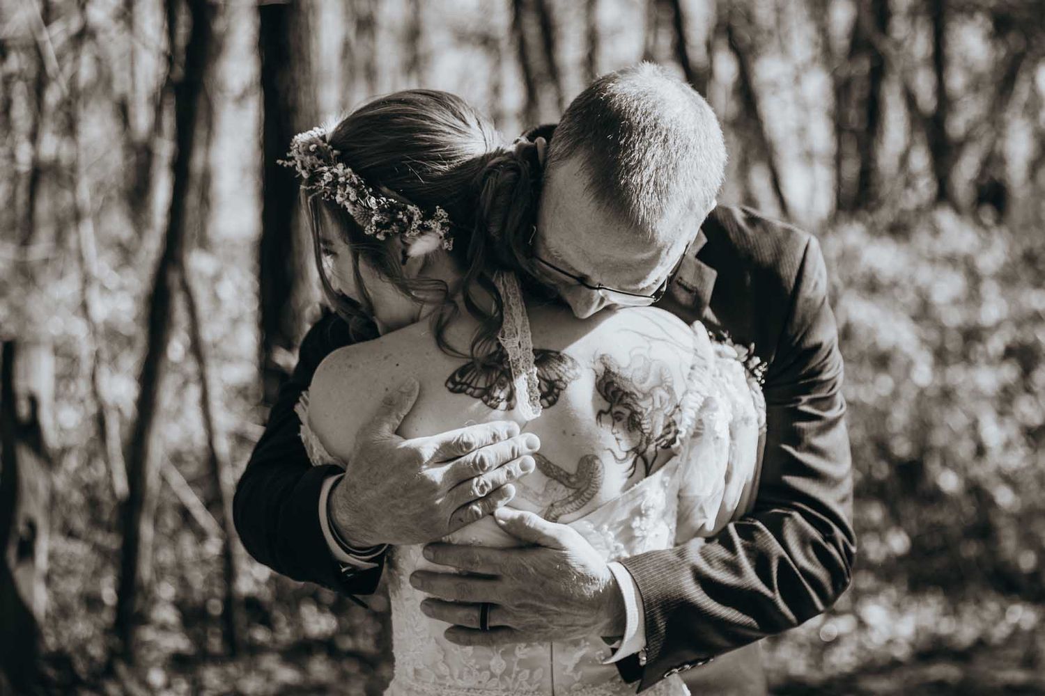 A romantic black and white photo sequence showing a couple sharing tender kisses in a wooded outdoor setting.