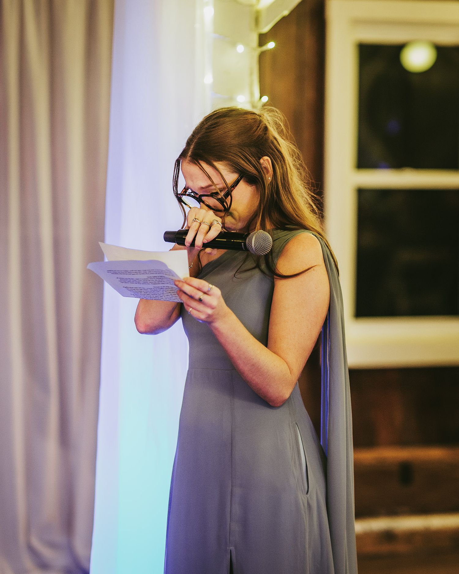 Wedding photographer capturing moments through a professional camera at an indoor reception venue.