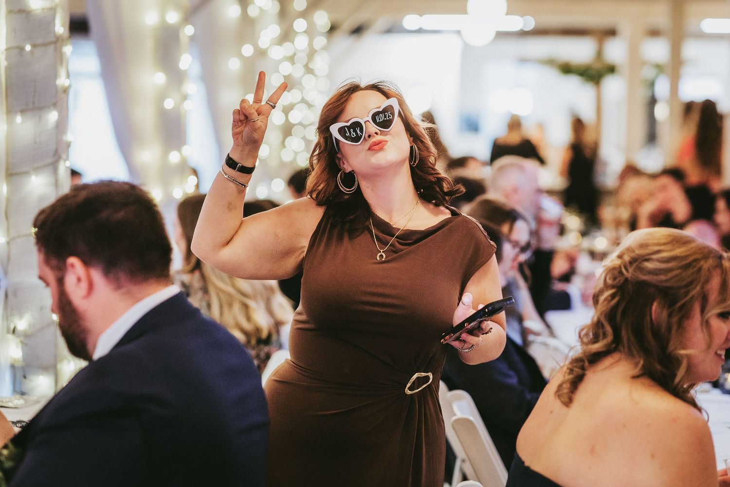 Wedding reception dance floor filled with celebrating guests under string lights.