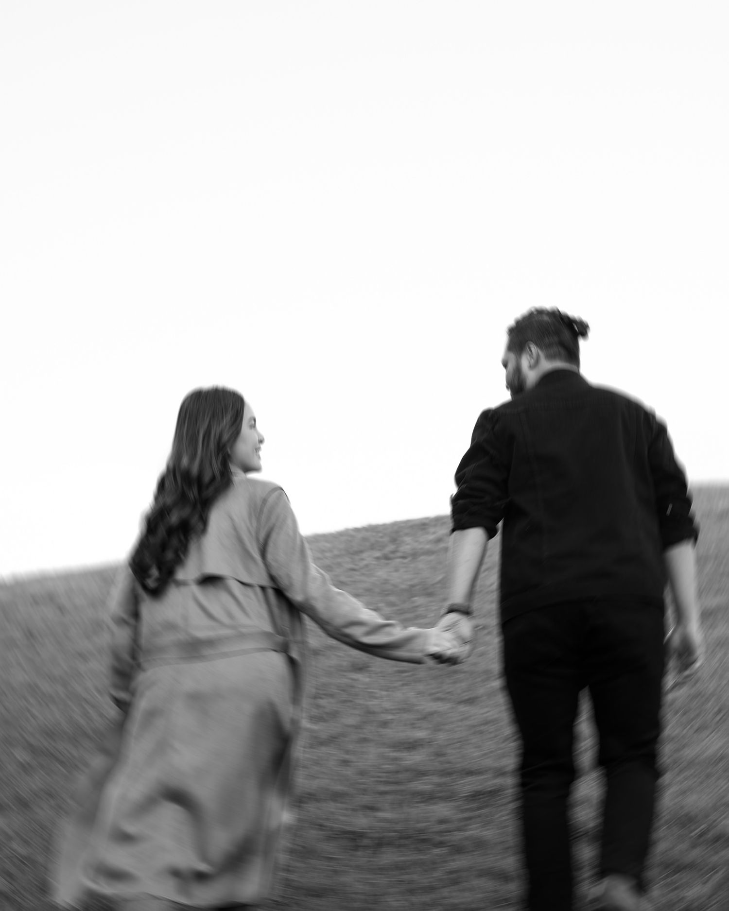 Couple walking holding hands portrait at Birrarung Marr in Melbourne.