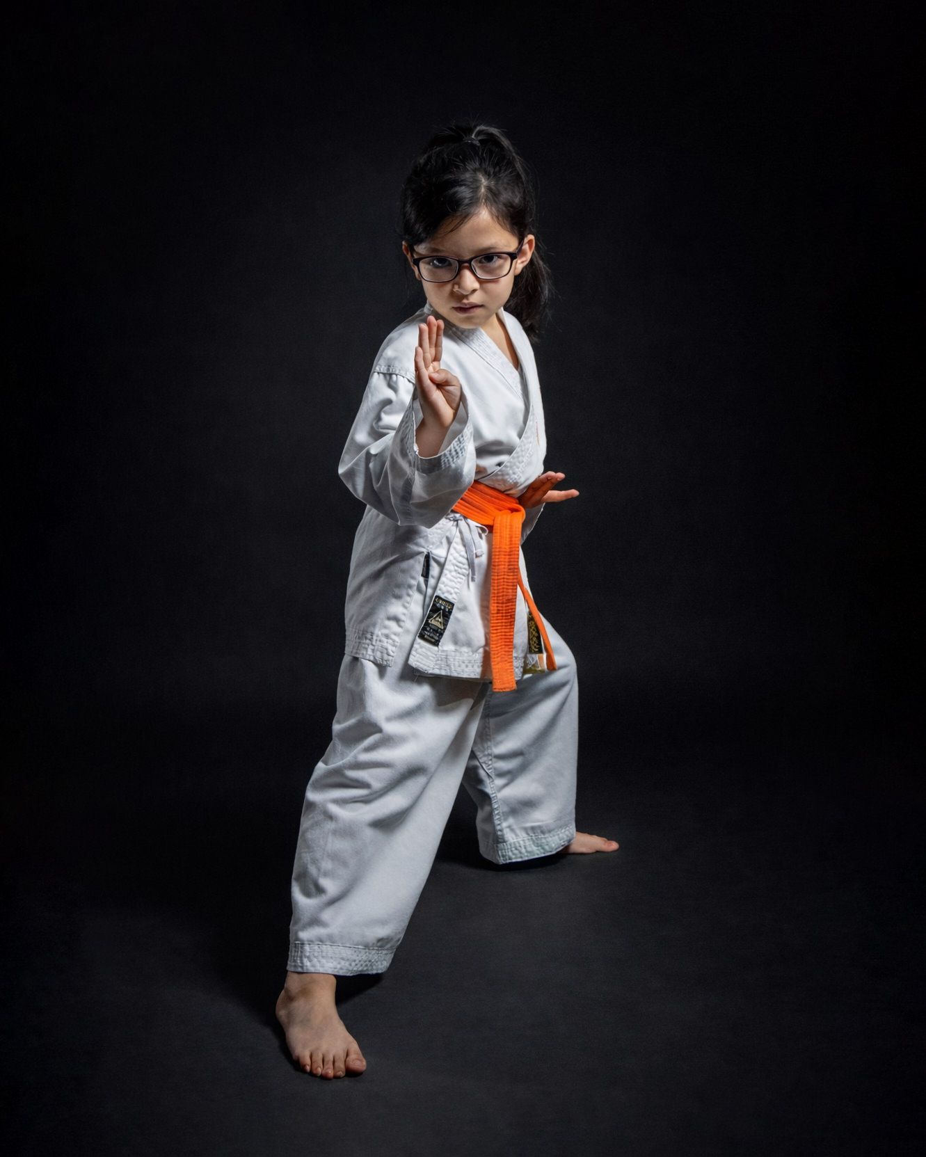 A martial artist in a white uniform striking a powerful pose against a dark background.