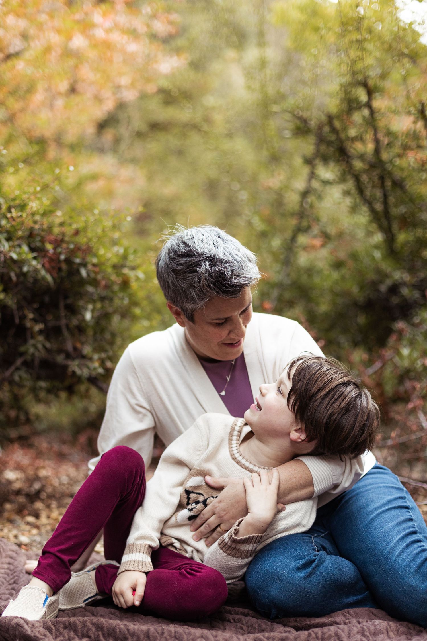 Intimate autumn moment captured on a blanket surrounded by fall foliage.