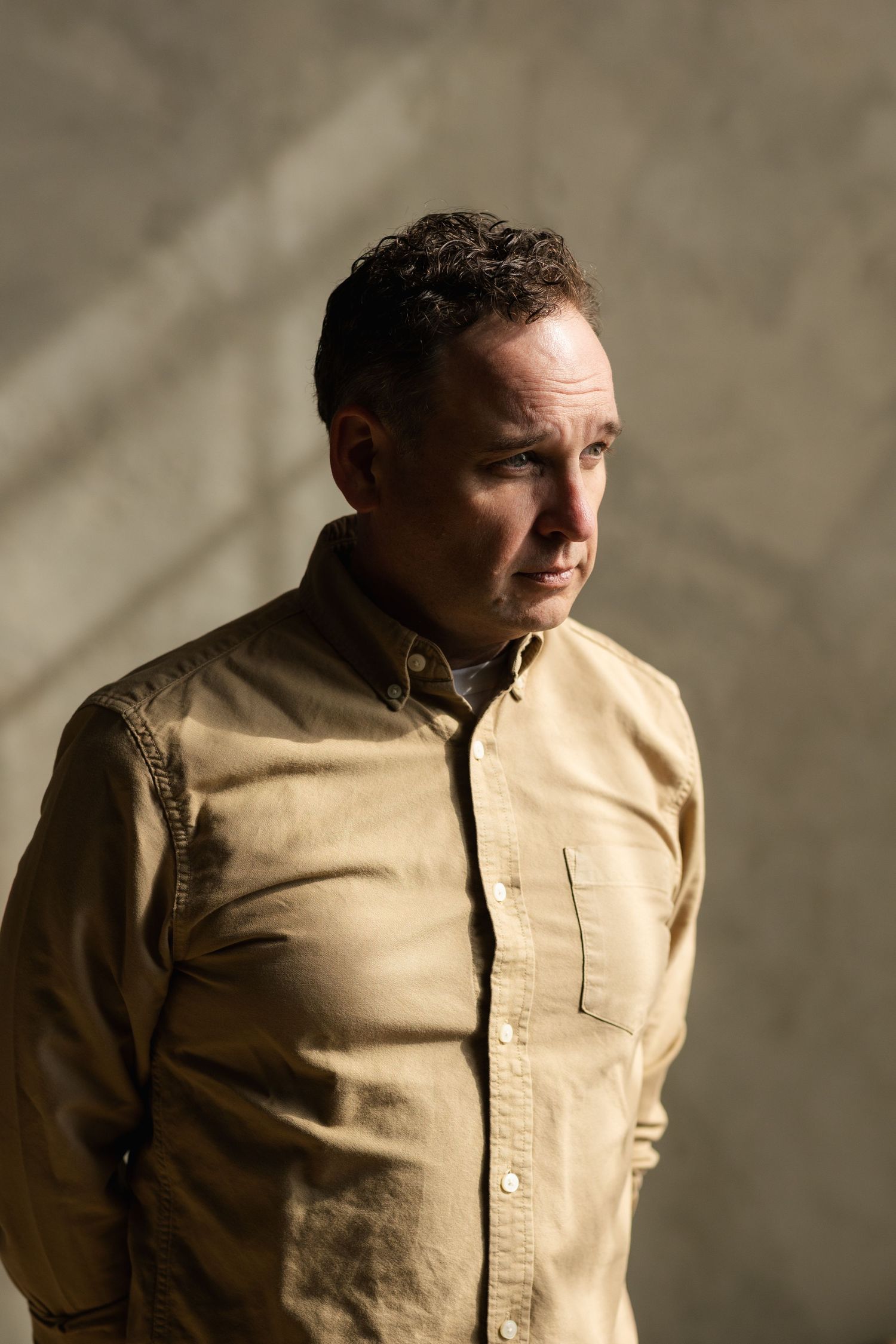 Person in beige button-up shirt shown in multiple angles against neutral background.