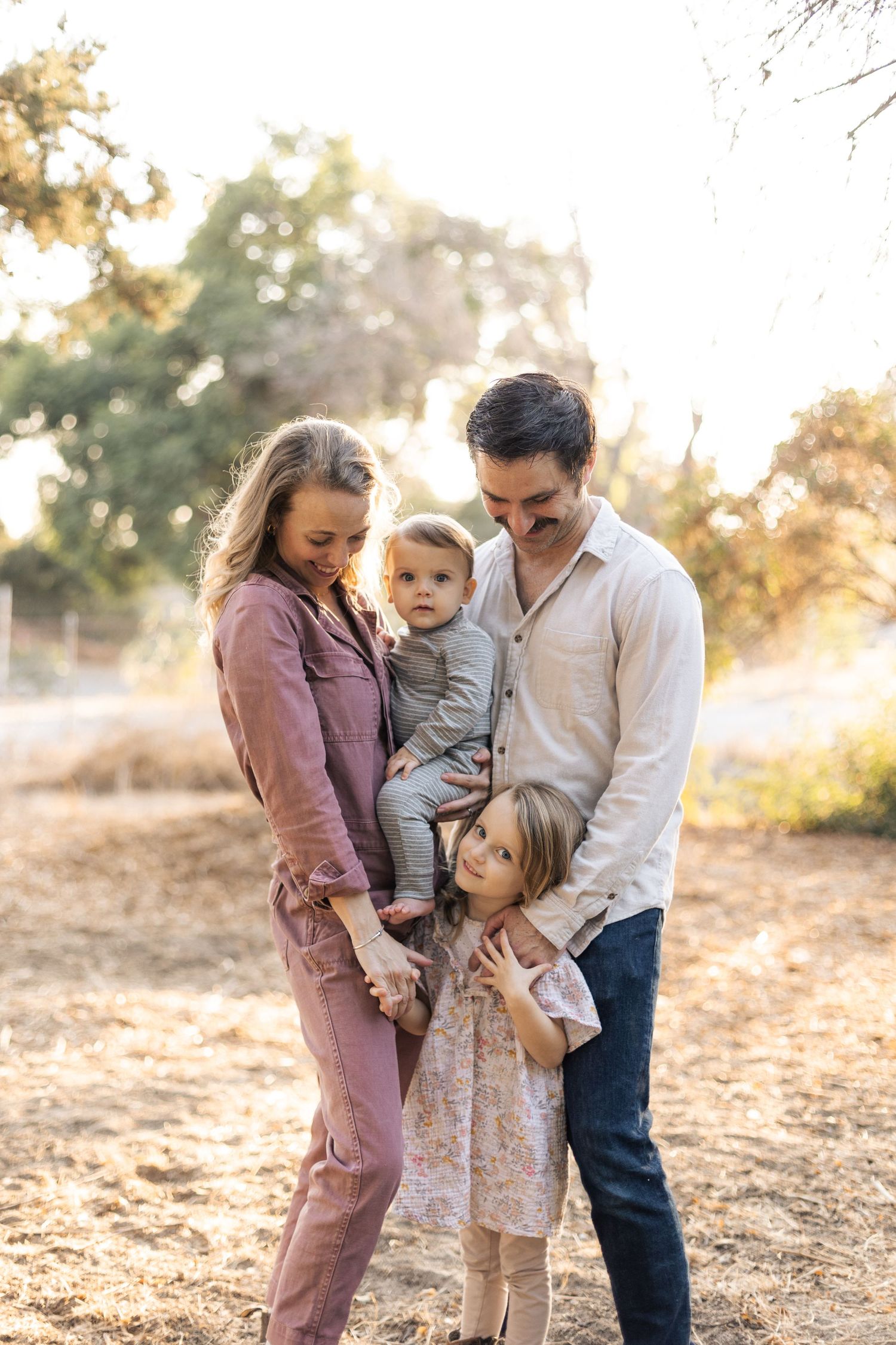 Family portrait session at golden hour in a natural outdoor setting.