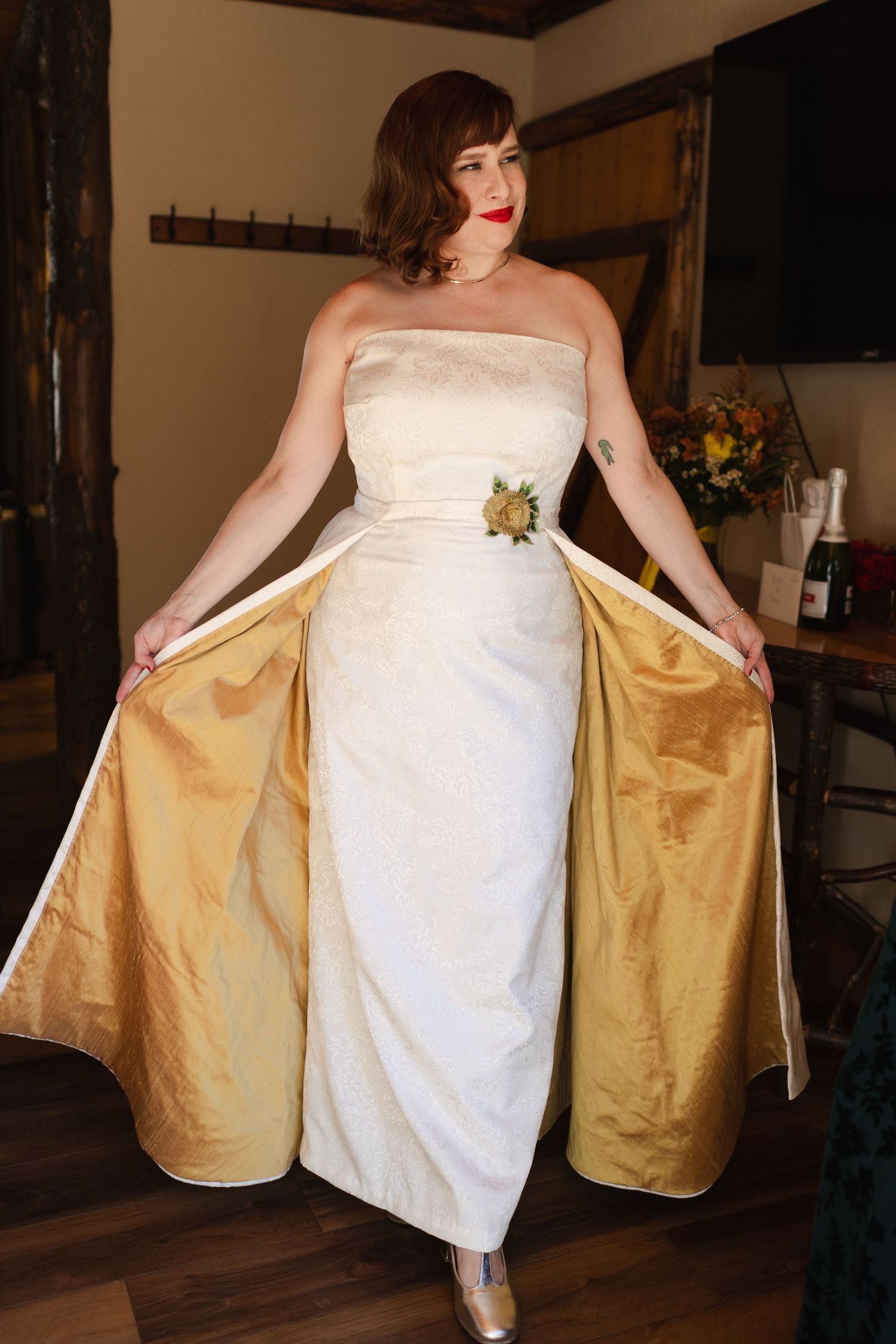 Person in white wedding dress revealing gold lining underneath.