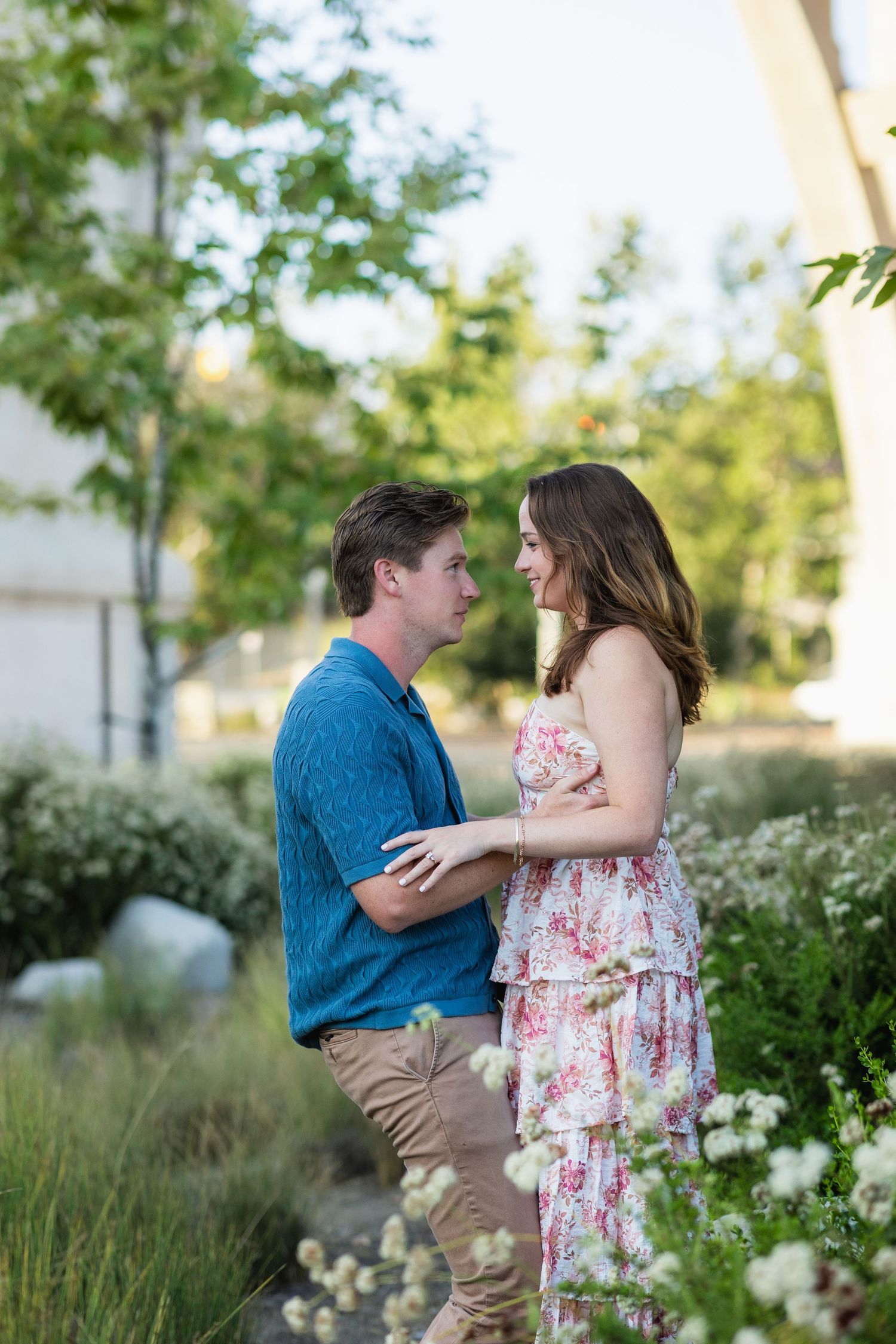 Couple shares tender moments in a lush garden setting during golden hour.