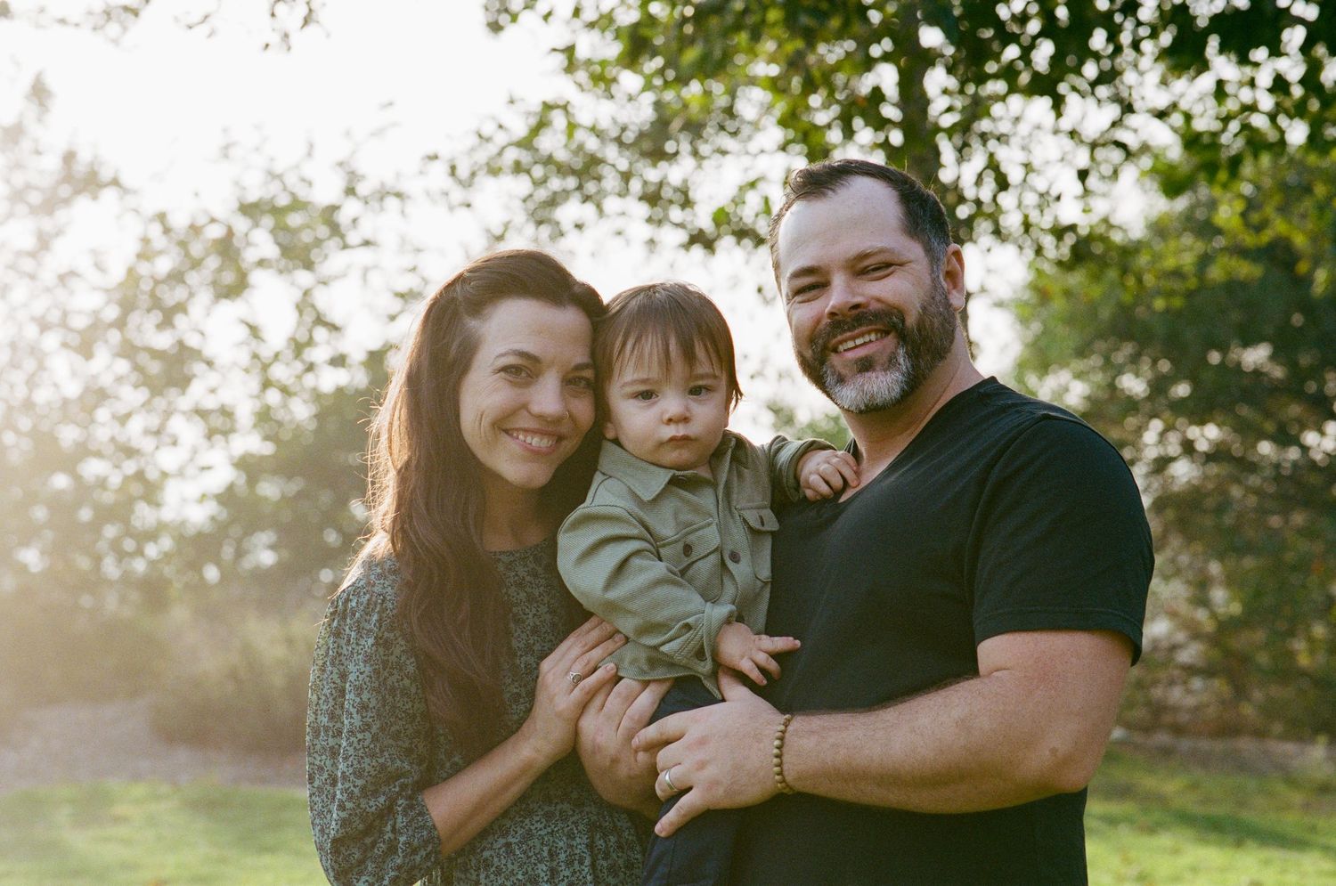 Family portrait session outdoors with natural lighting and greenery.