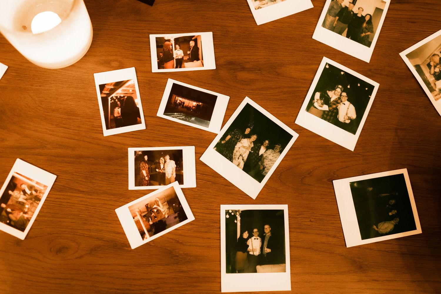 Polaroid photos scattered across wooden table surface.