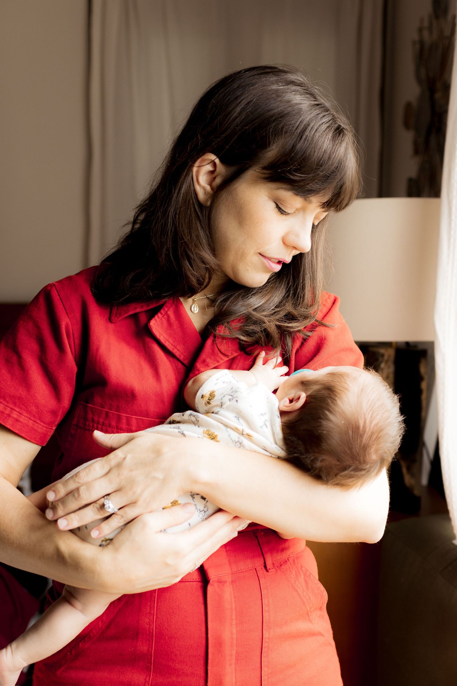 Tender moments captured during an indoor newborn photoshoot in red attire.