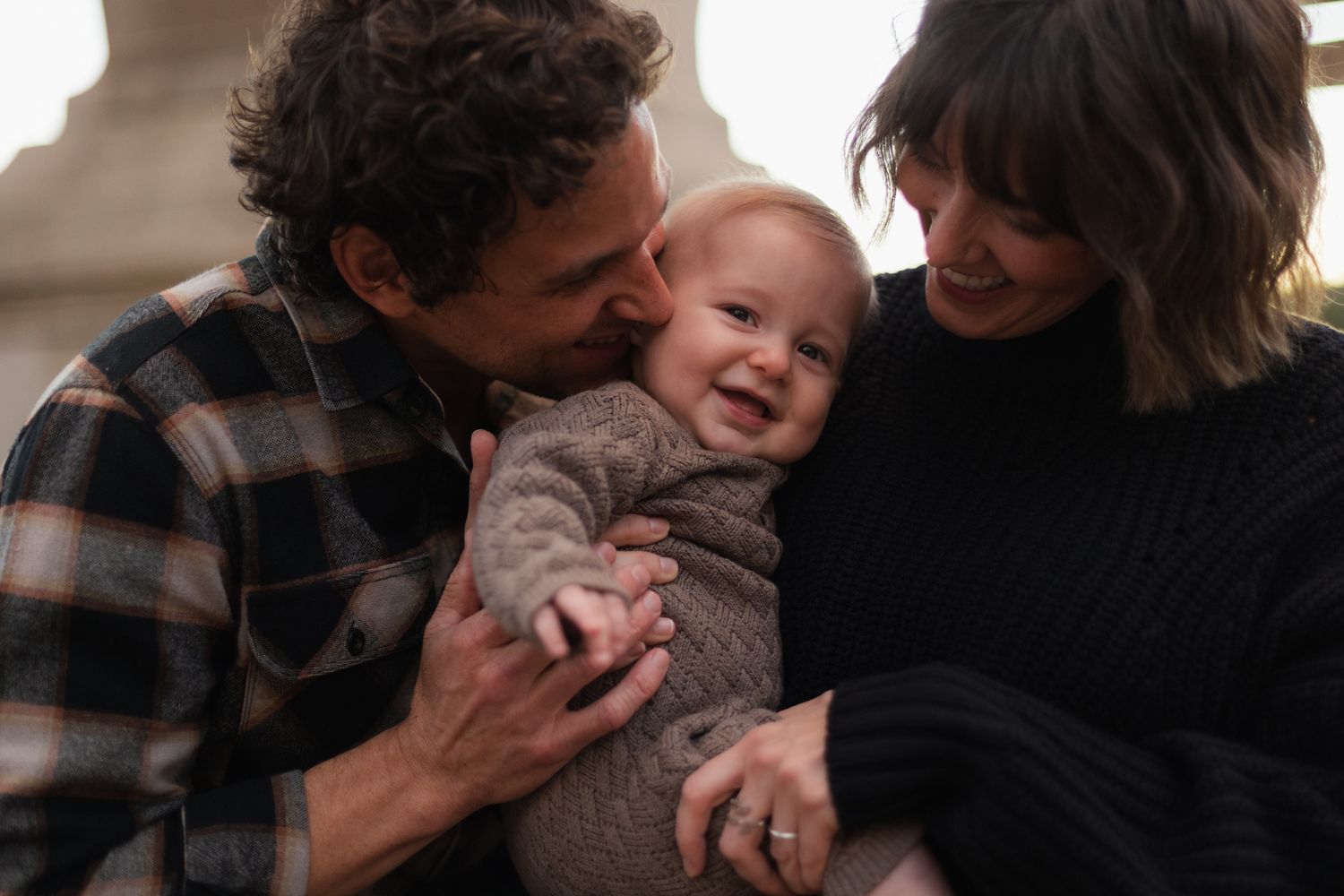 A series of intimate family moments captured in black and white showing tender interactions and laughter.