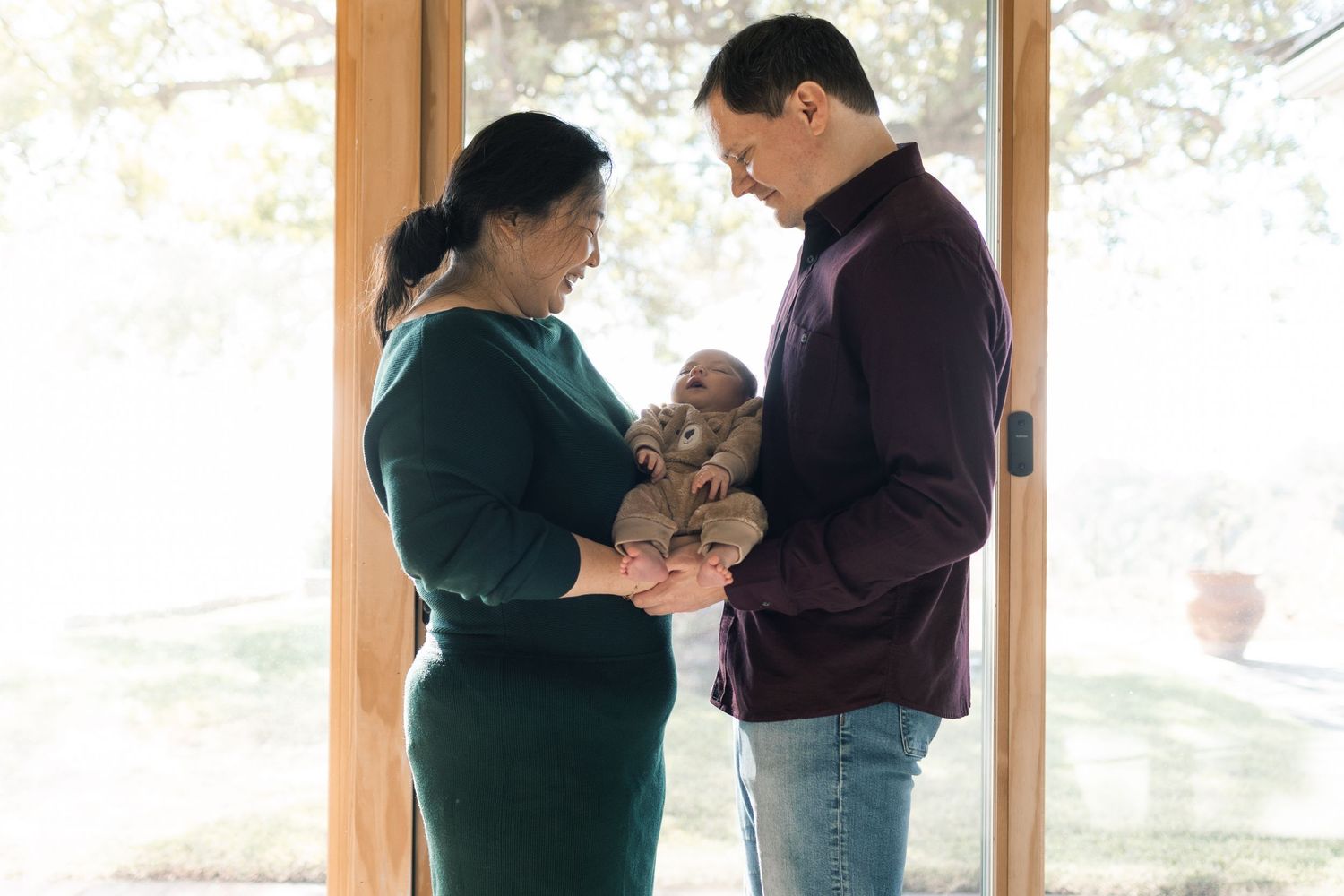 A tender maternity photo session showing a couple in warm indoor lighting.
