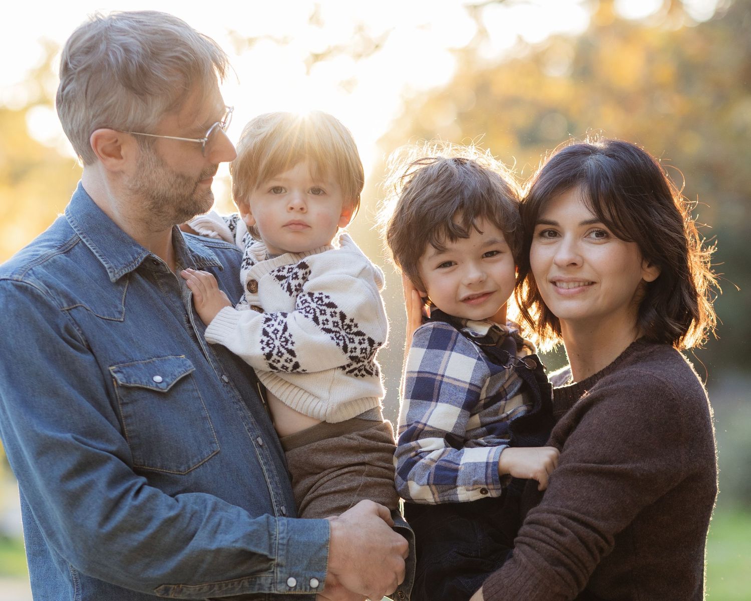 Family portrait series outdoors with denim and casual wear at sunset.