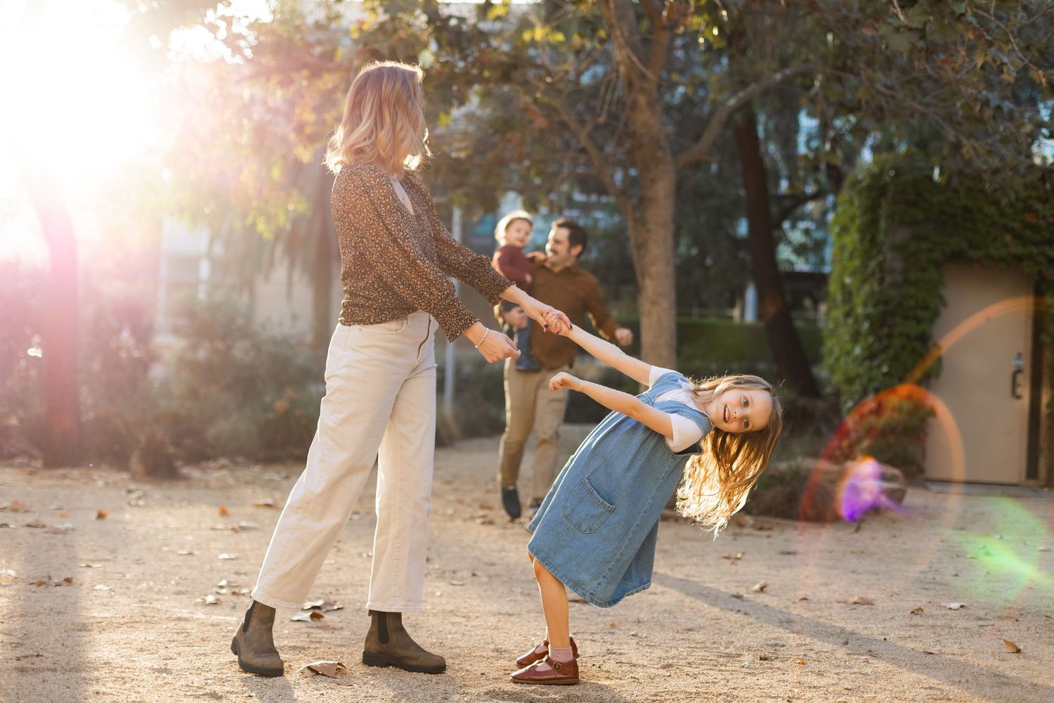 People walking and interacting outdoors during golden hour.