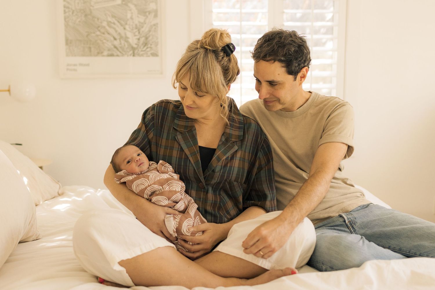 Intimate family lifestyle photography session in a bright white bedroom.