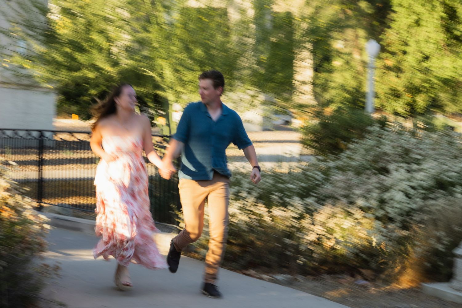 Couple walking together through a garden path with blooming flowers.
