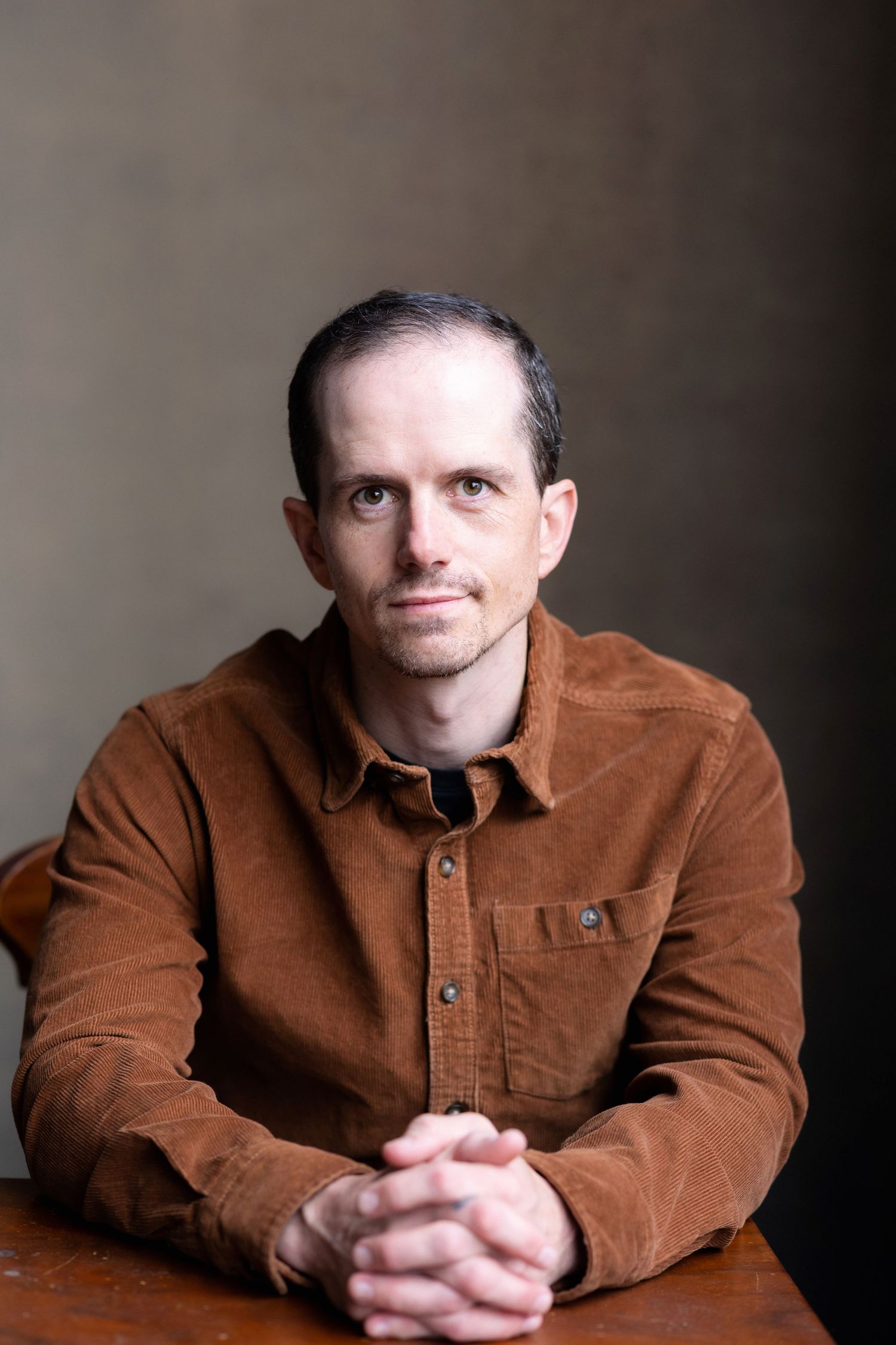 Portrait series of a person in a brown corduroy jacket against a dark background.
