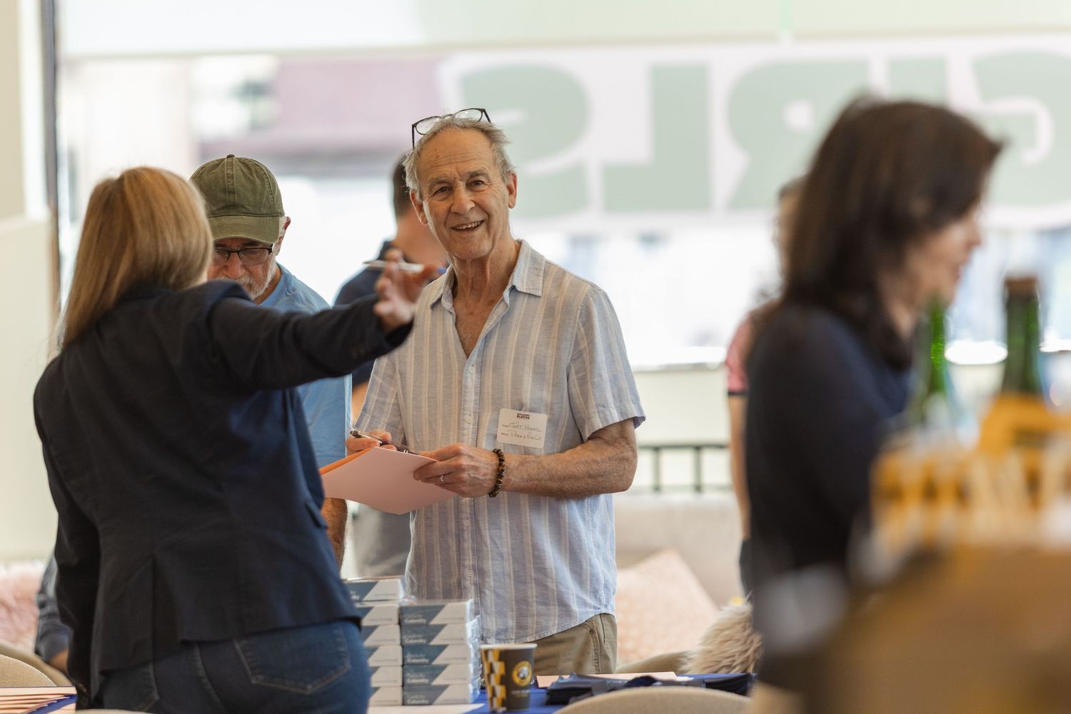 People interact and socialize at a casual gathering or event with drinks in hand.