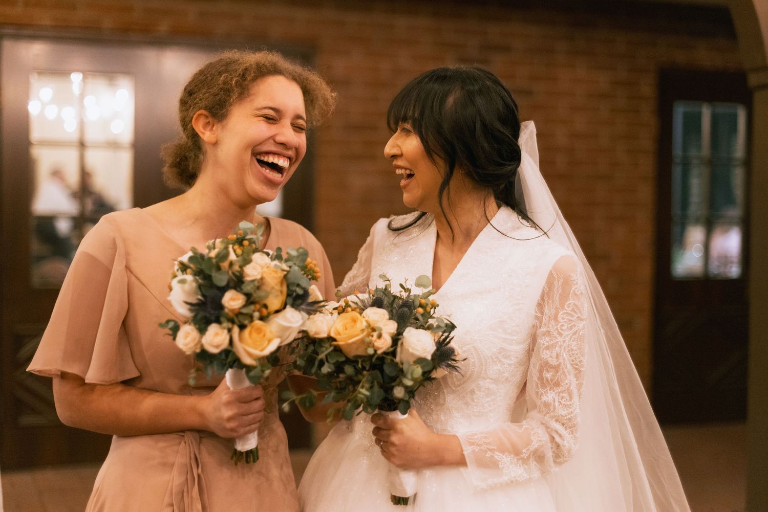 A joyful wedding moment with bouquets of peach and white flowers.