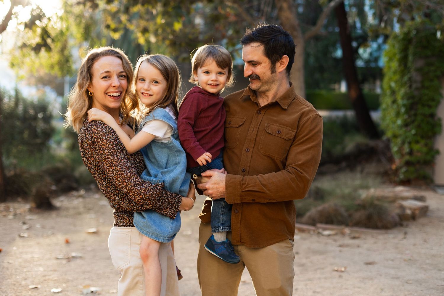 Family portrait session at golden hour in an outdoor natural setting.