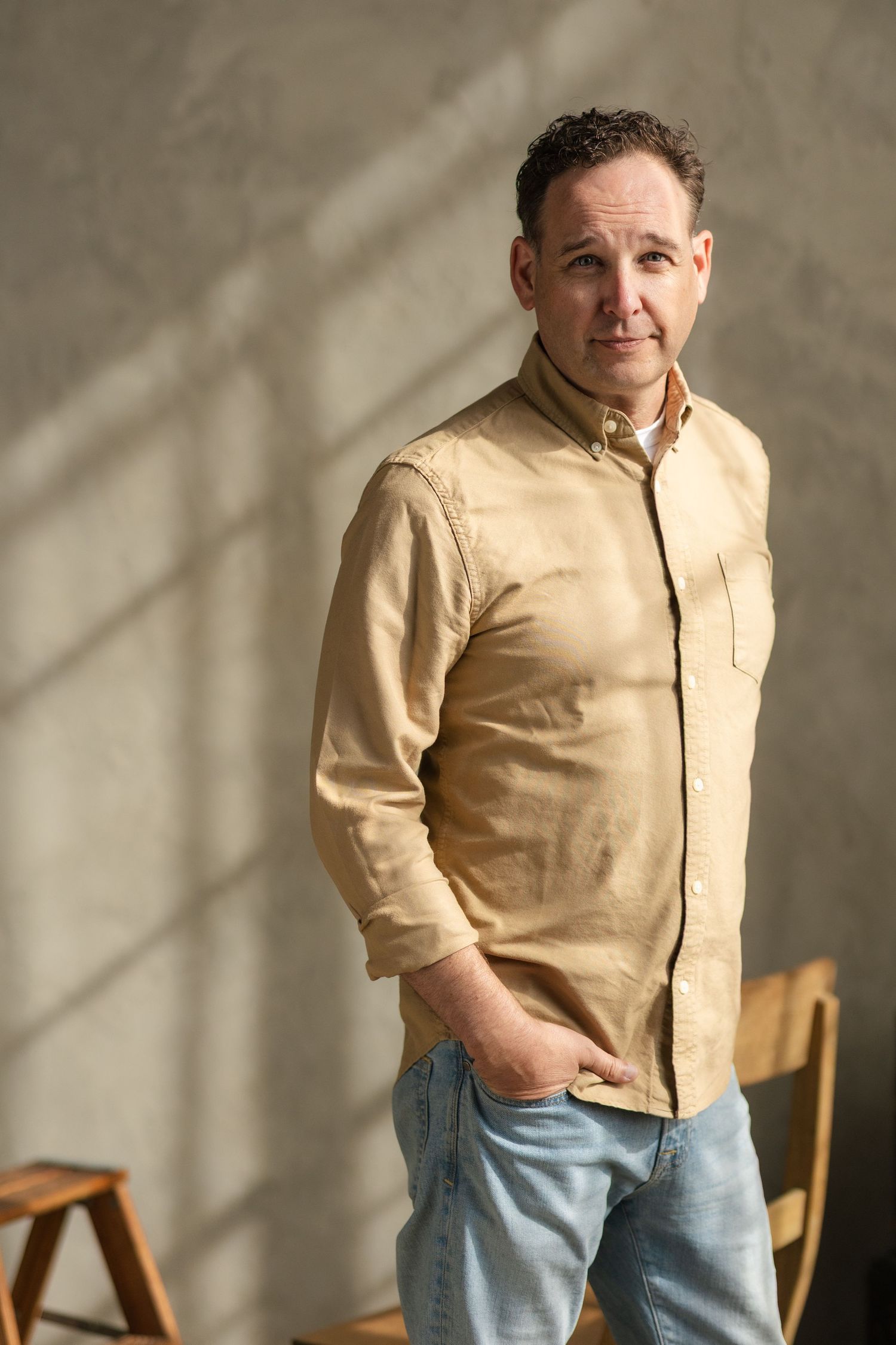 Multiple poses in beige button-up shirt and jeans against neutral studio background.
