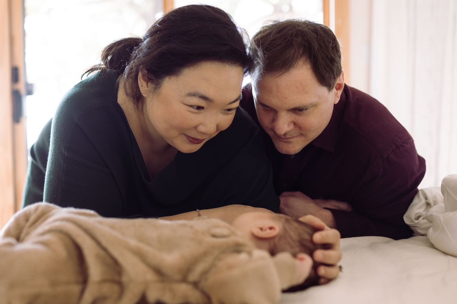 A loving couple shares an intimate moment during an indoor maternity photoshoot.