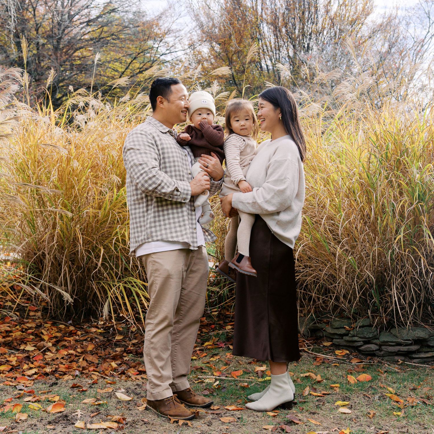 Autumn engagement photos with tall golden grass and fallen leaves in the background.