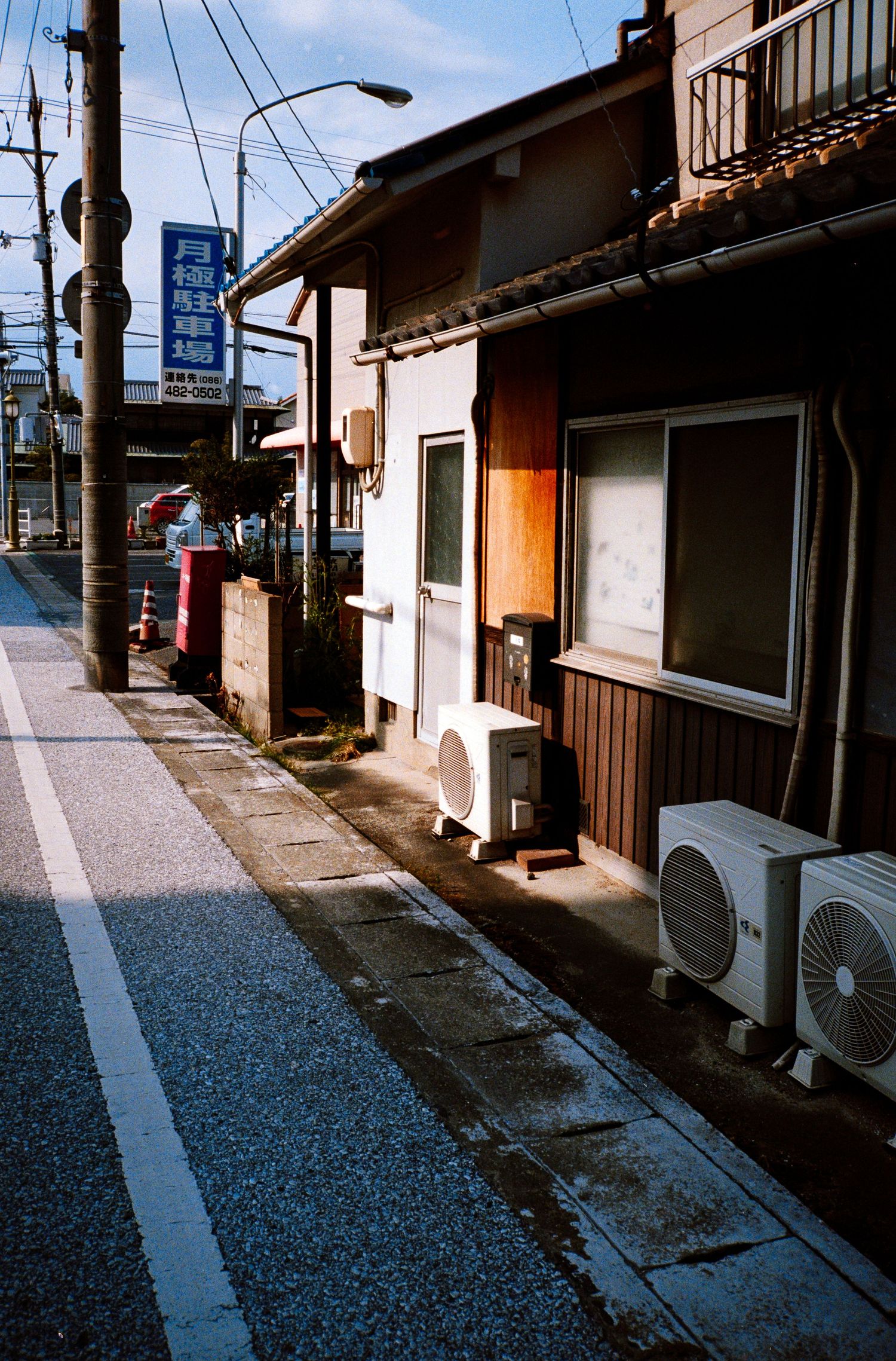 Sequential view of a traditional Japanese residential street with utility poles and air conditioning units.